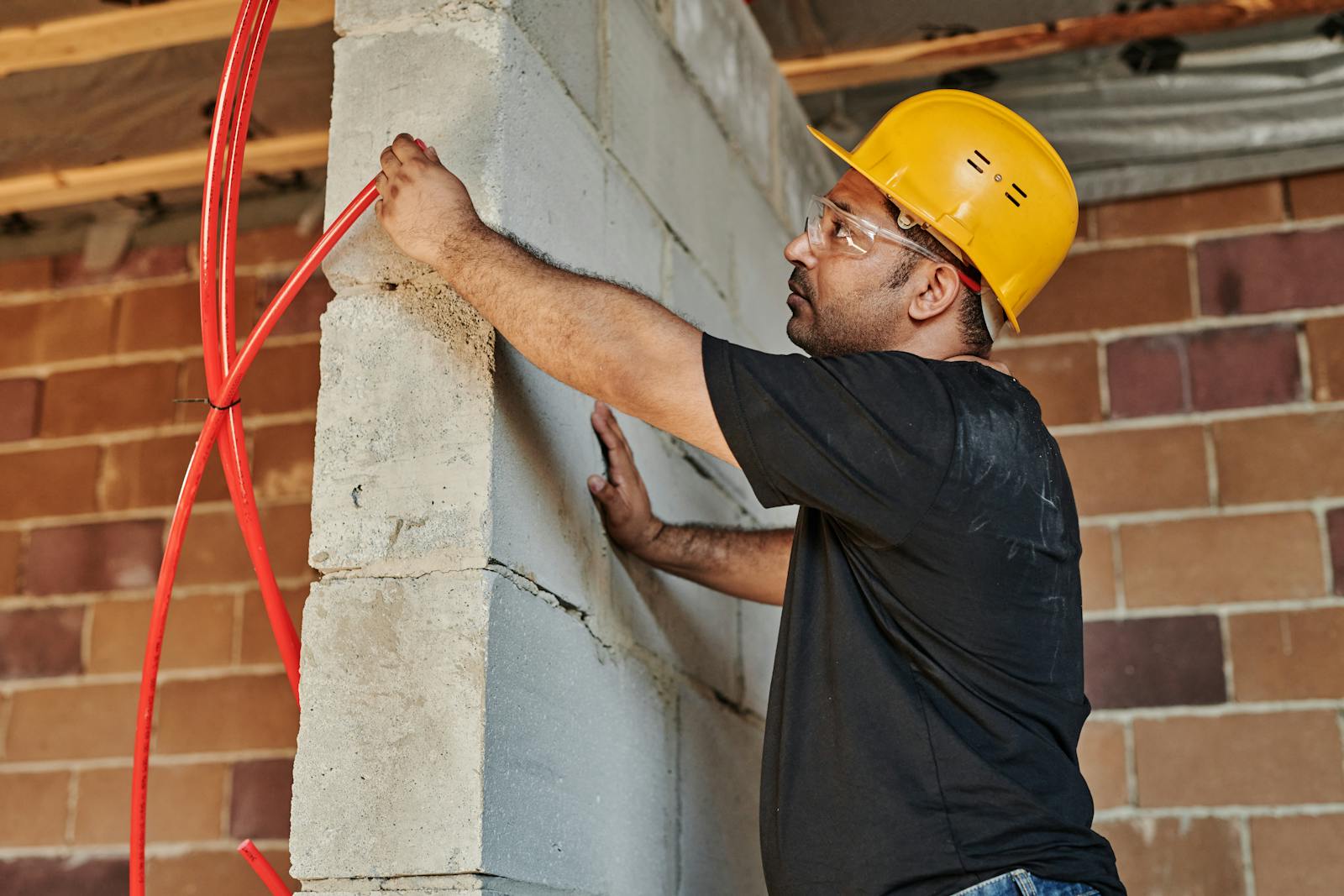 Man in Black T-shirt Holding a Wire